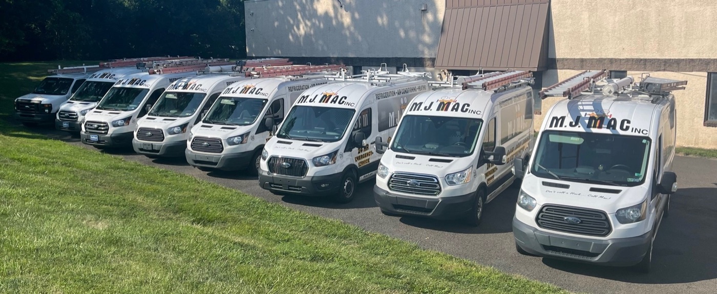 M. J. Mac Inc. service vans lined up outside the company building.