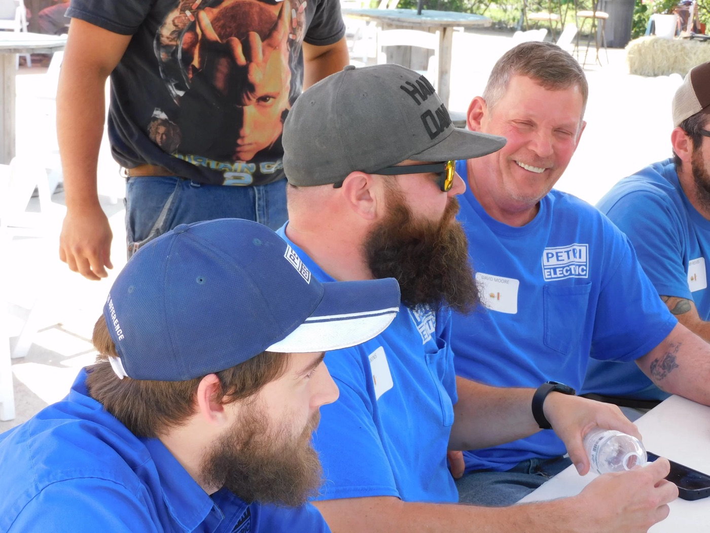 Petri Electric employees in blue company shirts at an outdoor team gathering