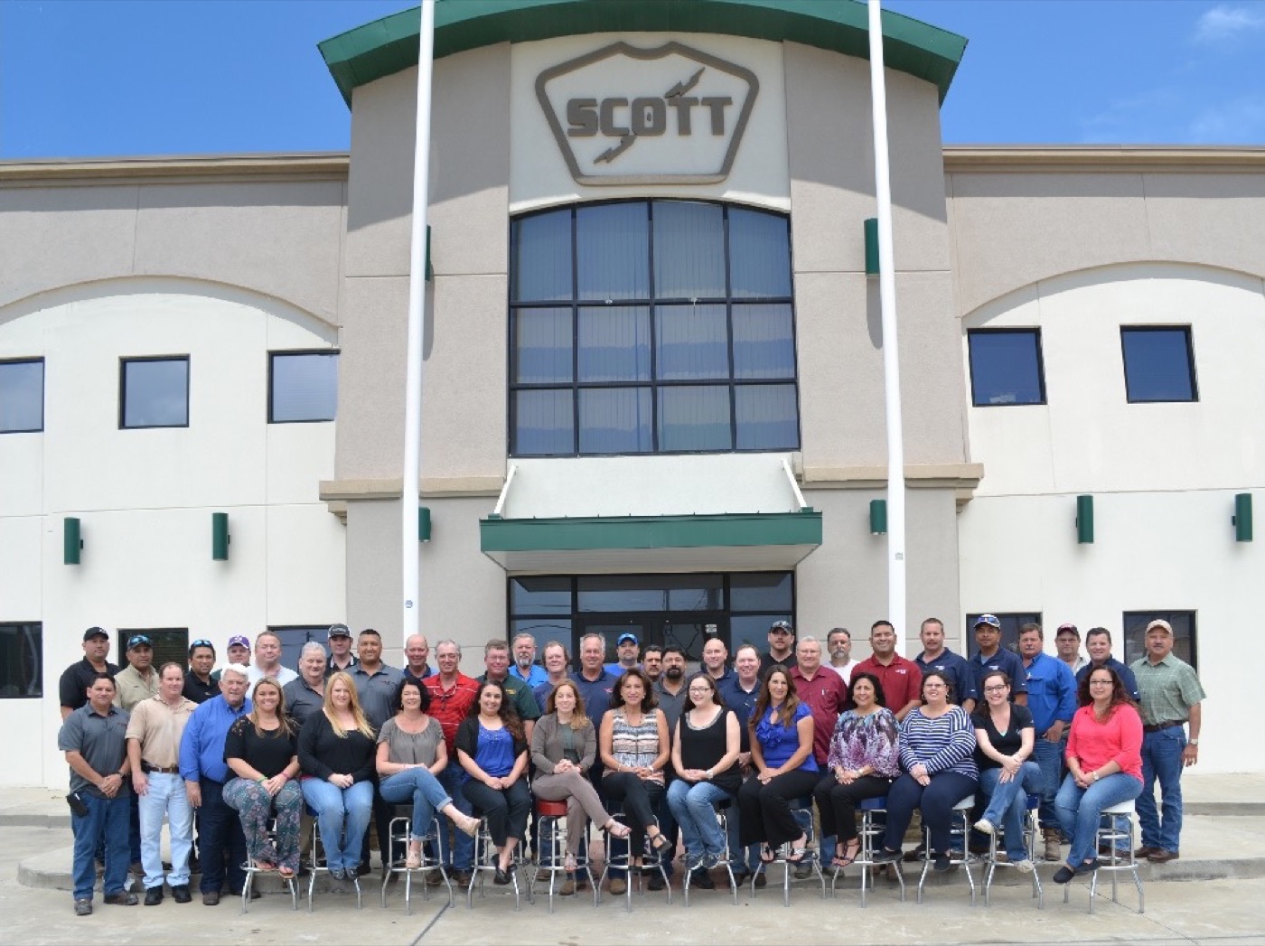 The Scott Electric team outside its Corpus Christi workplace beneath the Scott company shield.