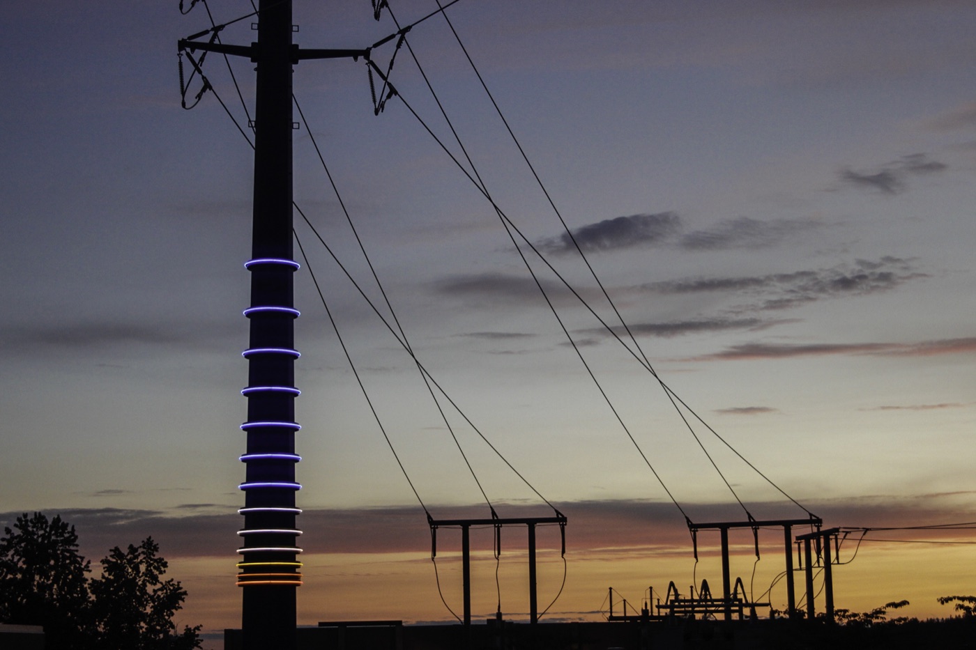 Illuminated utility pole and electrical infrastructure at sunset, featured by Western Utility Telecom.